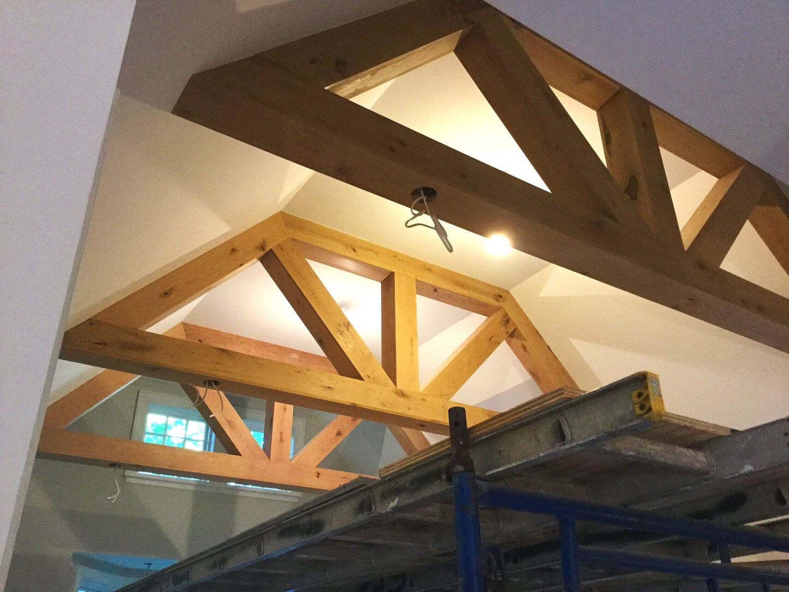 Exposed timber trusses framing a vaulted ceiling during new home construction