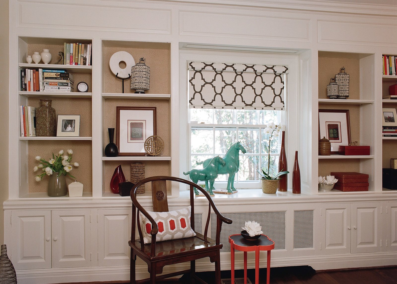 Irving Park living room with white built-in bookcases, a geometric Roman shade, a turquoise horse sculpture and a red accent table