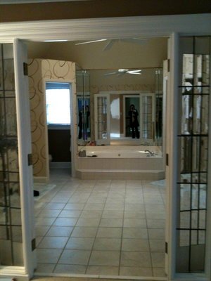 Before the remodel: the original primary bath with beige floor tile and a built-in tub