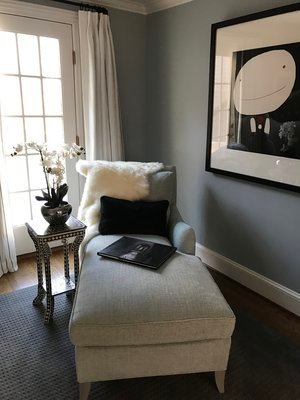 After the remodel: a reading corner with a linen chaise, orchids and large framed art against grey-blue walls