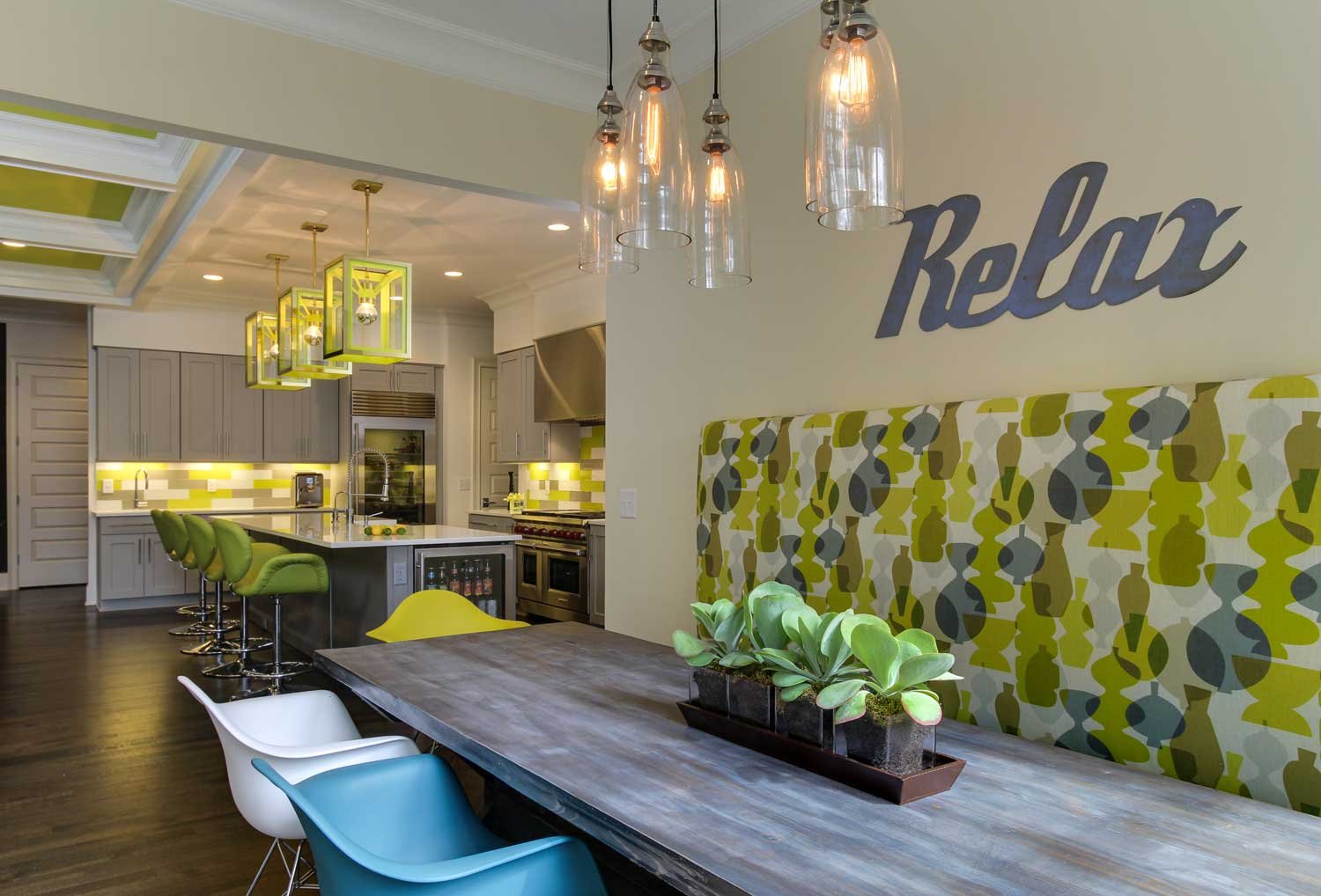 Mosley Road kitchen and breakfast banquette with chartreuse lantern pendants, a graphic upholstered bench and a long weathered-wood table