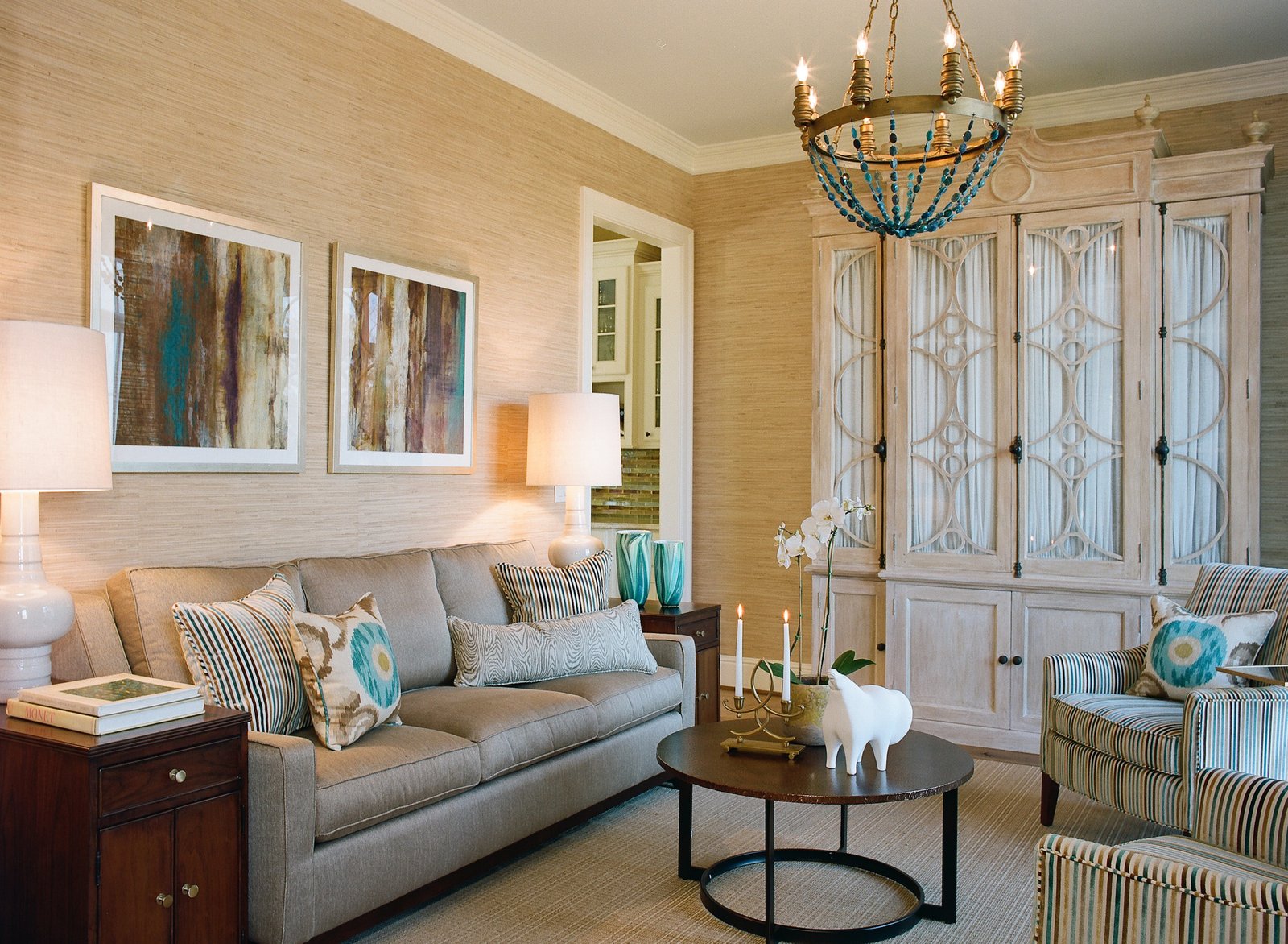 Henson Forest living room with grasscloth walls, abstract art and a beaded chandelier